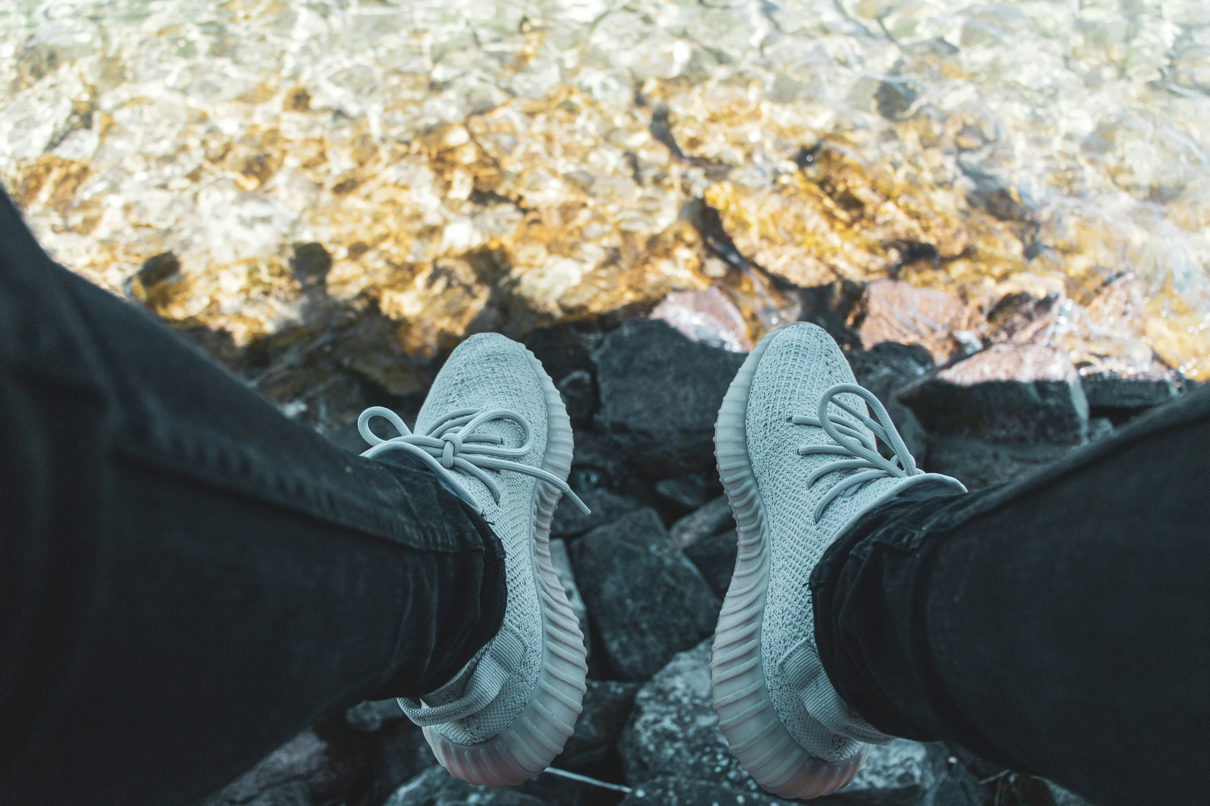 the feet of a man who is wearing blue and white tennis shoes