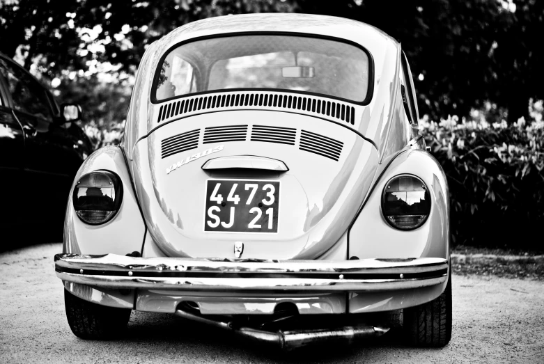 an old beetle is parked with its hood open
