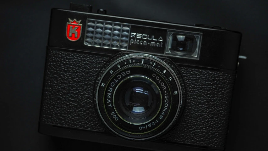 a black analog camera with a round lens