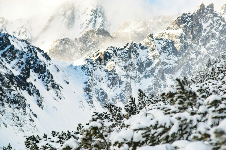 snow covered mountains with blue sky above them