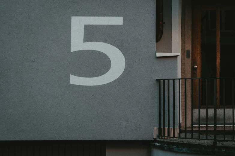 the number five on a wall on the outside of a building