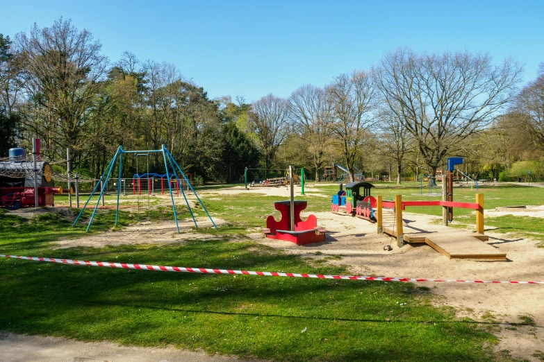 some children play area with several slides, swings, and slides