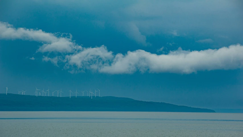 a sky view with a bunch of clouds and some wind turbines