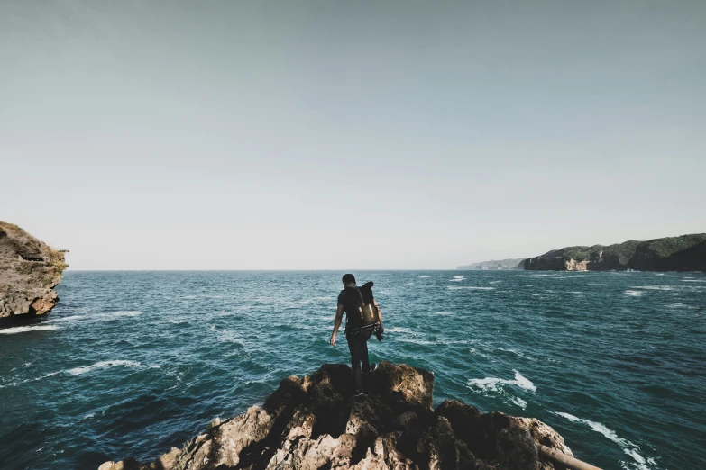 a person with a backpack standing on top of an island