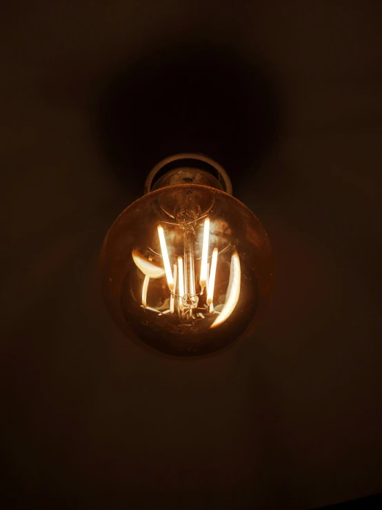 a light bulb on the wall shining in a dark room