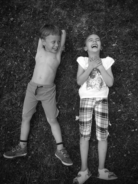 two children laying on their back on the ground