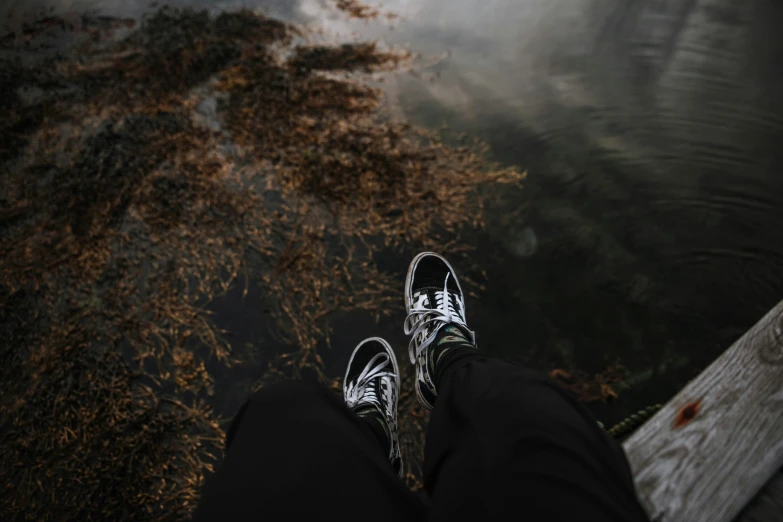 a person is standing on a pier above water