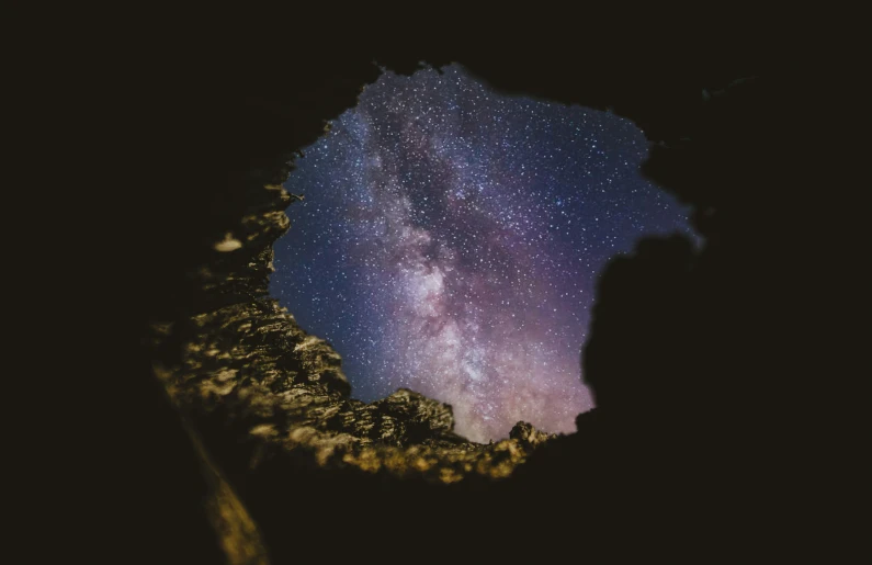 the milky over a rock formation with some trees in front