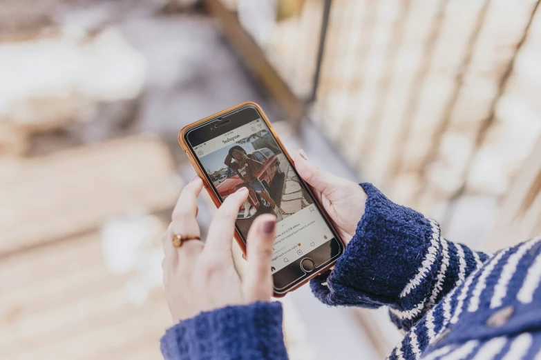 a man holding an iphone while taking a po