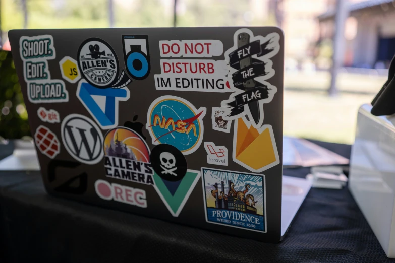 a close up of a laptop with stickers on it