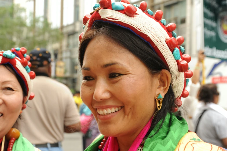 a women wearing headgear and earrings smiling at the camera