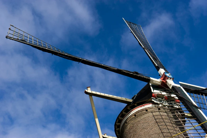 an old mill on a cloudy day with blue sky