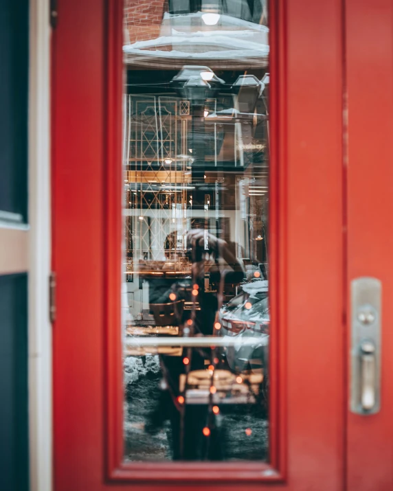 a red door with glass, looking out into the street