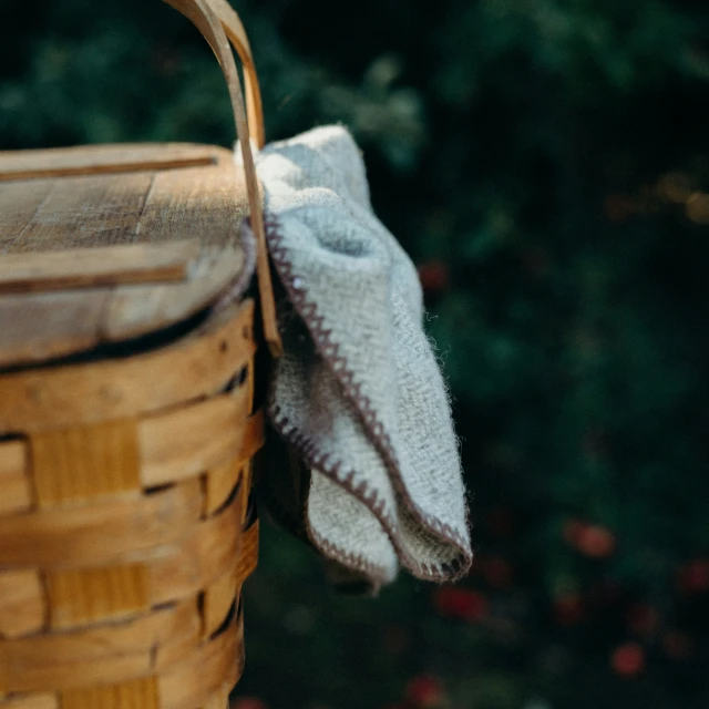 a hat and some white knit gloves in a basket