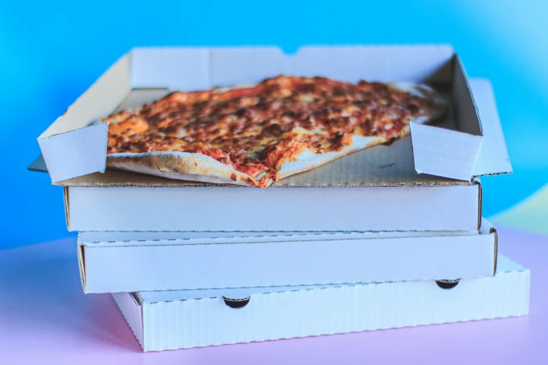 three pizza boxes stacked on each other and one is filled with cheese, tomato sauce and other toppings