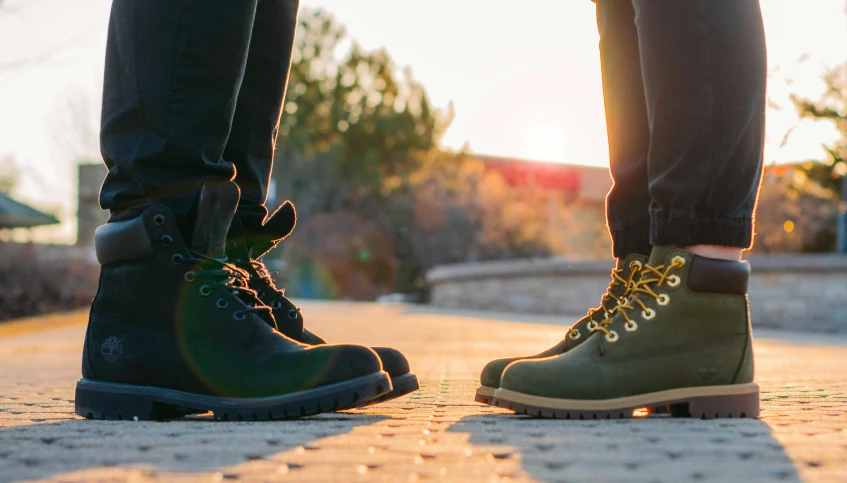 two people standing next to each other in boots