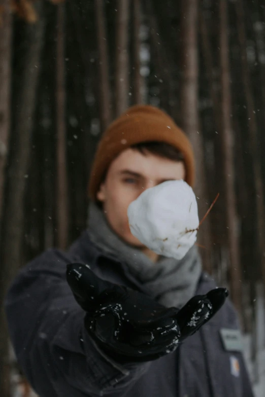 a person in winter gear blowing up the wind