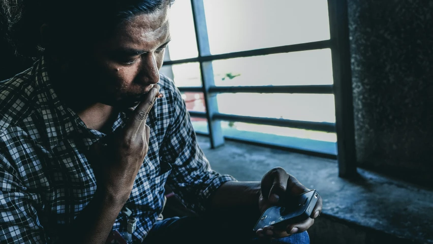 a man sitting down drinking out of a water bottle