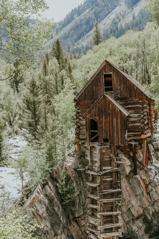 a wooden cabin on a mountain with stairs