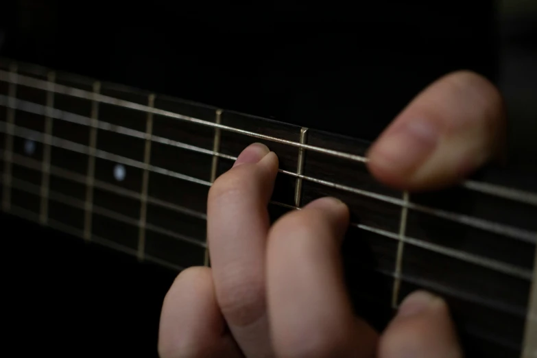 someone is playing guitar and holding their fingers on the strings