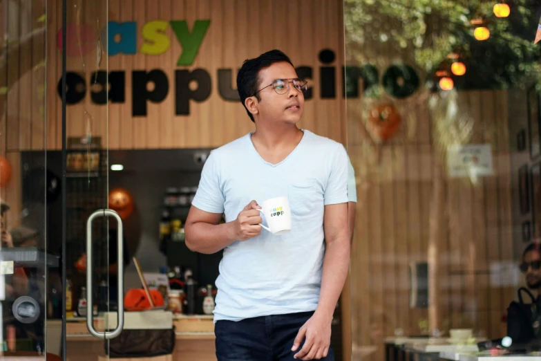 man in sunglasses and white shirt with coffee