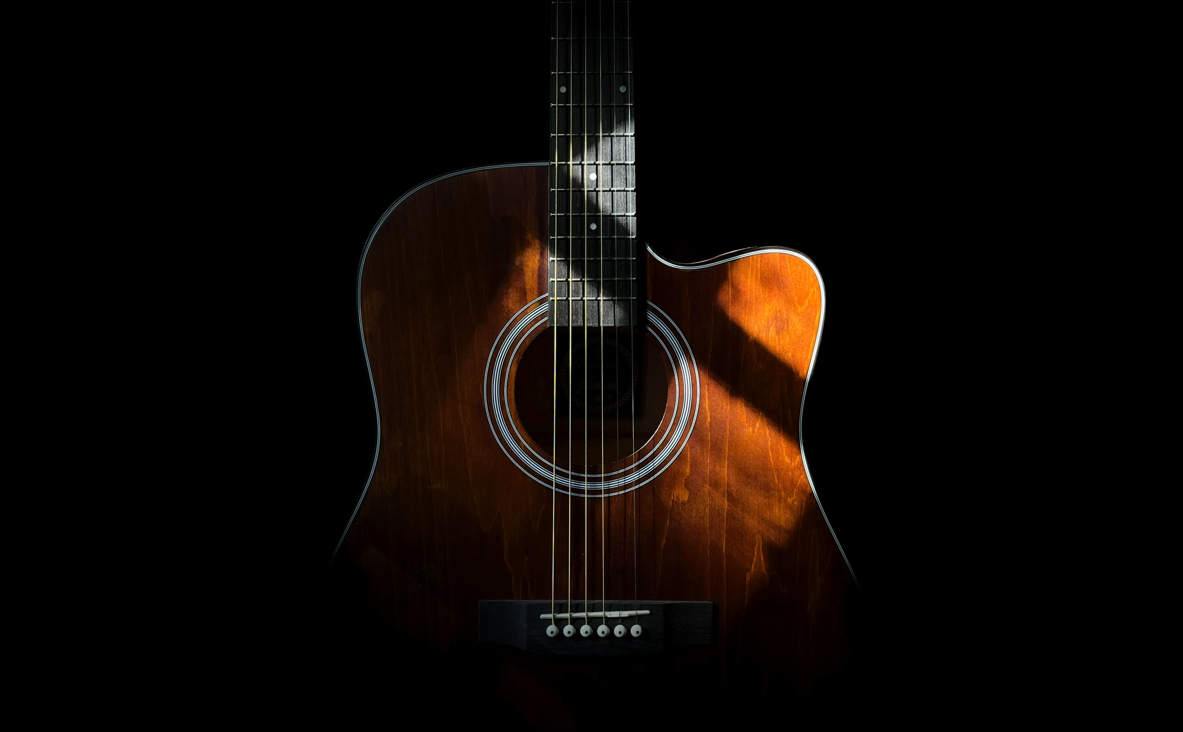 an acoustic guitar with a dark background