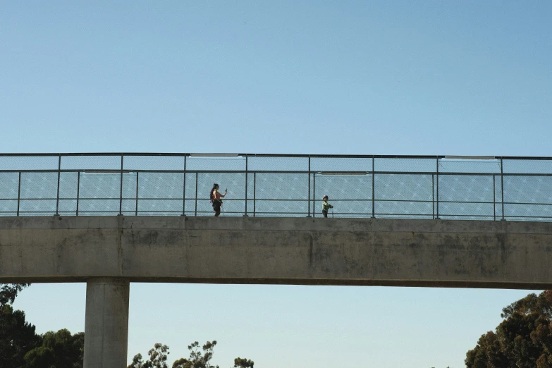 people walking across a bridge near the water