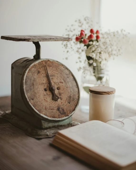 a wooden table topped with a plate clock next to flowers