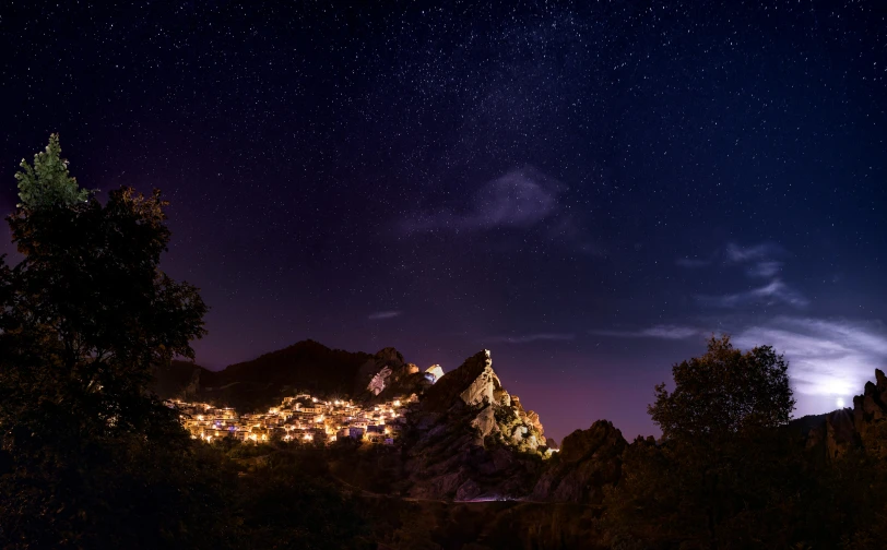 there is a night view from the ground of some hills