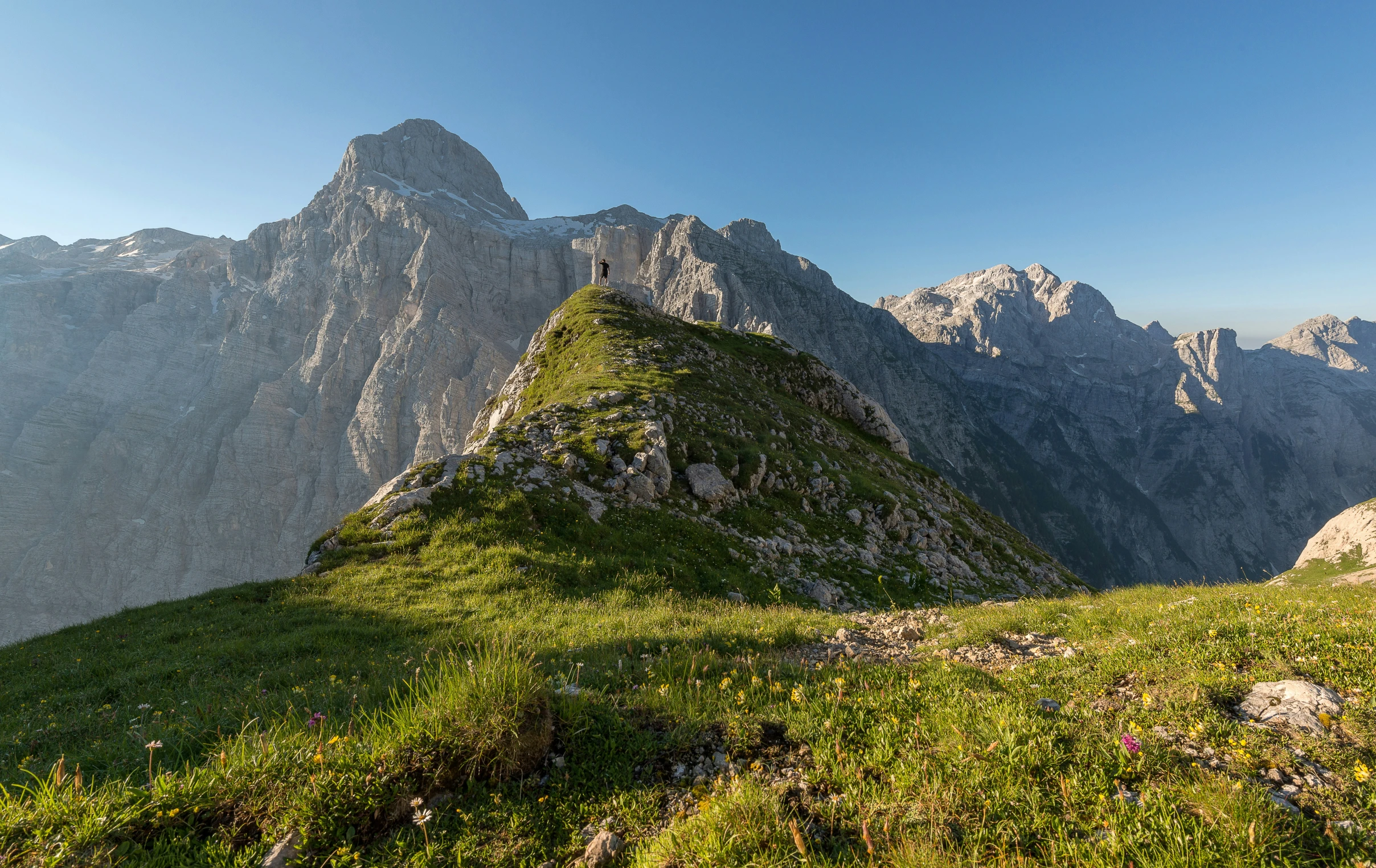 a grass covered hill with a few big rocks sticking out of it