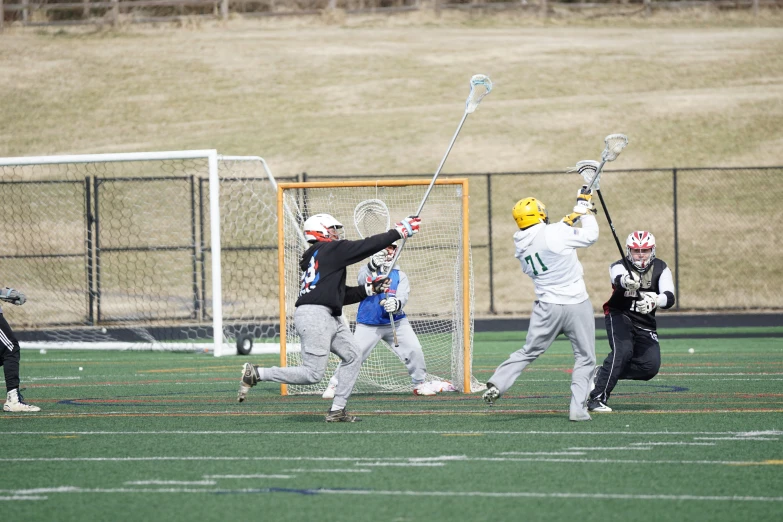 a group of people playing lacrosse on a field