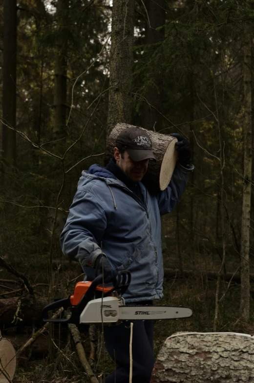 a man in a forest holding a chainsaw