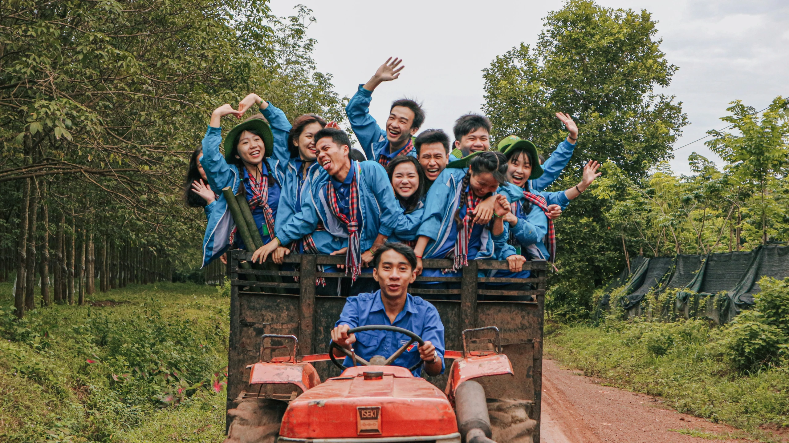 an asian group of people are riding in a tractor