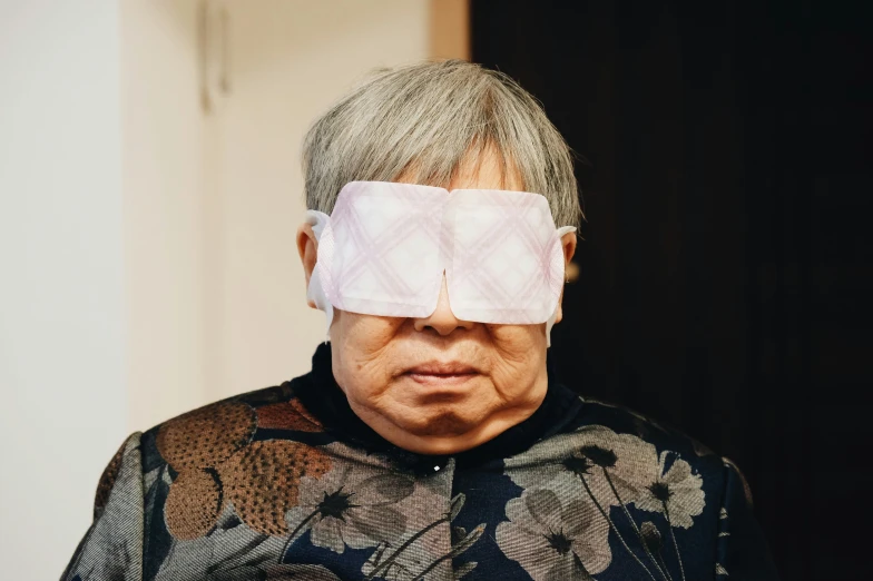 an older lady is wearing an eye mask