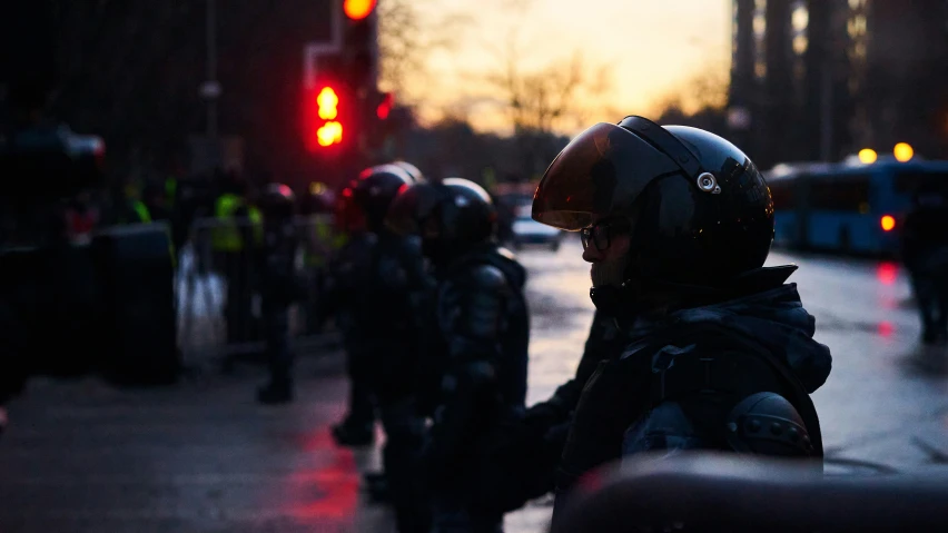 a man standing with a group of people and traffic lights behind him