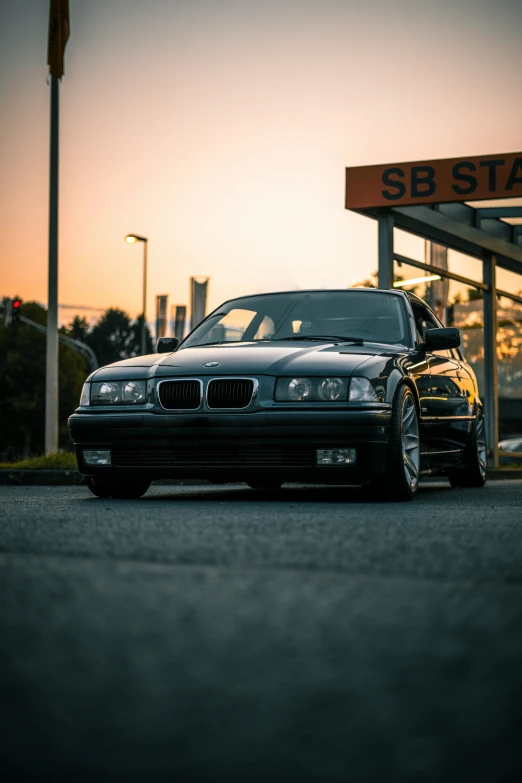 a car parked next to another car in front of a sunset