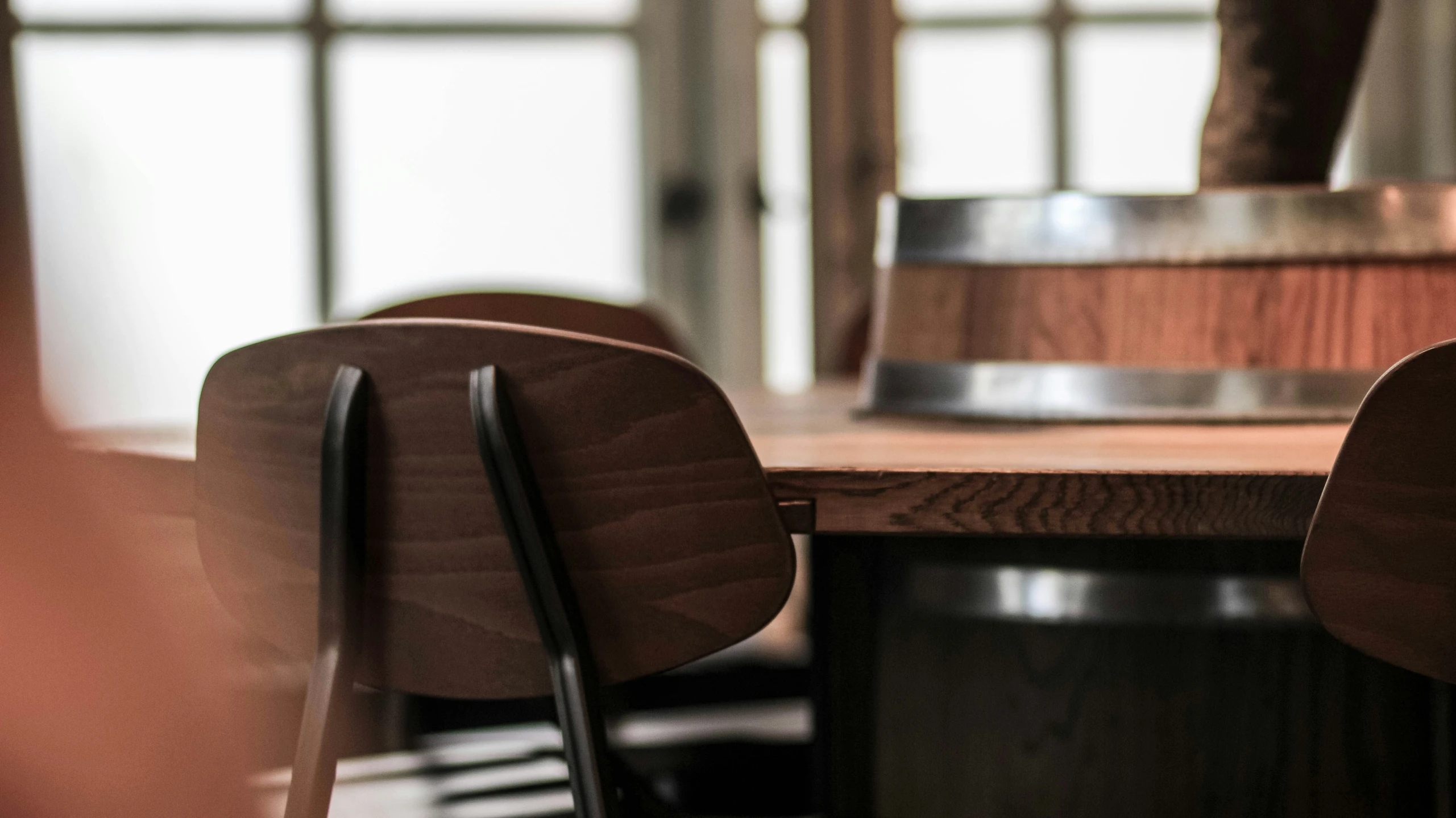 a wooden table that has two chairs and a stool