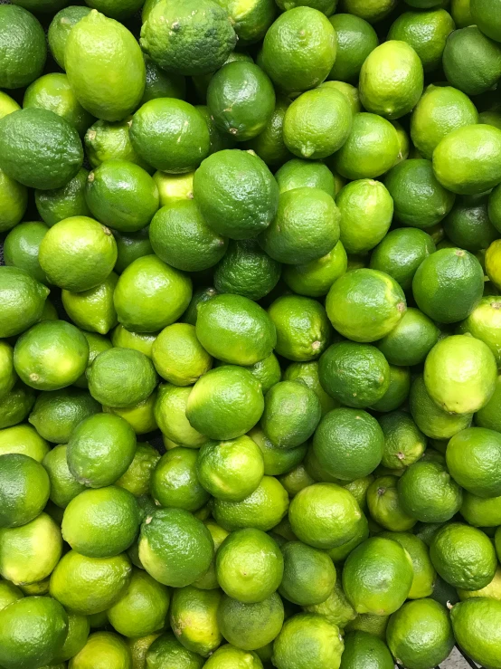 this green lemons and limes are in a basket