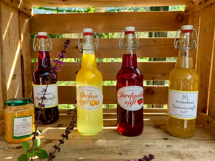 a group of alcohol bottles with some wild flowers