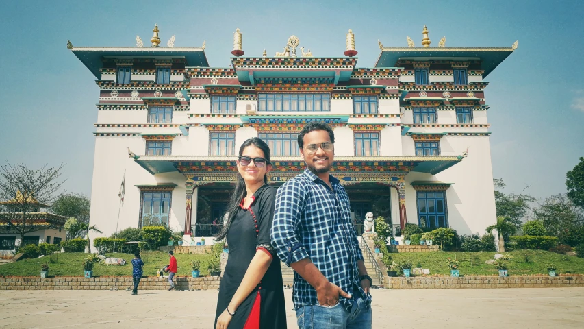 two people posing in front of a building