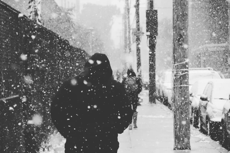 a woman is walking on a snow covered sidewalk