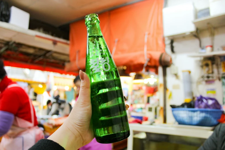 the person is holding a large green bottle