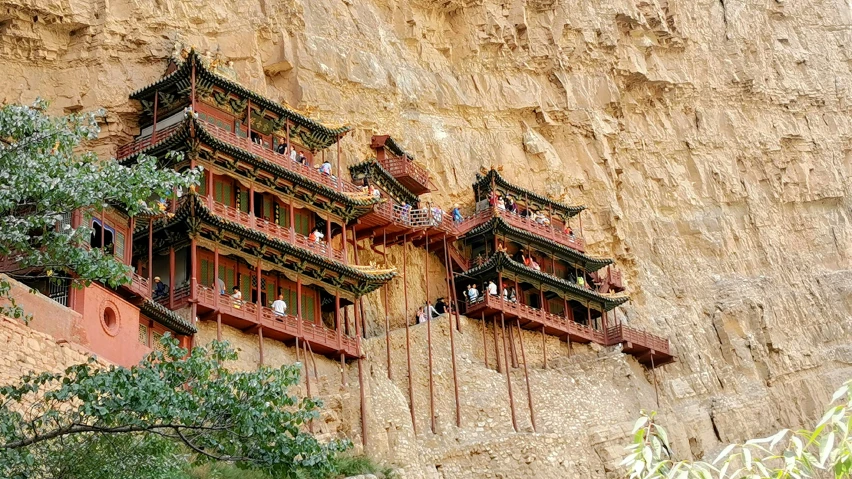 many wooden windows that are in the side of a cliff