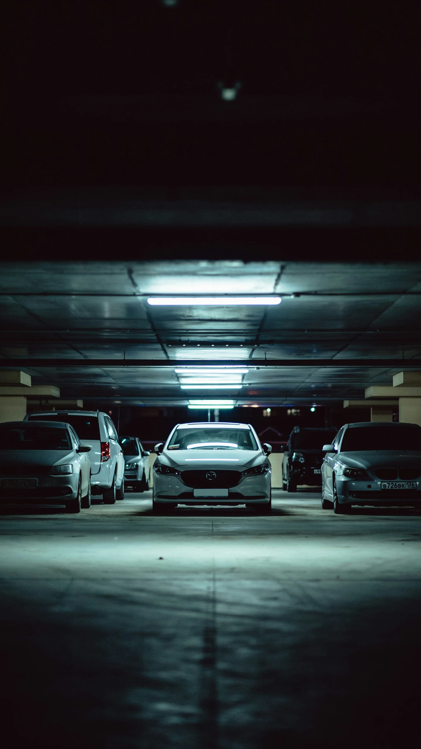 several vehicles parked inside a large, empty garage