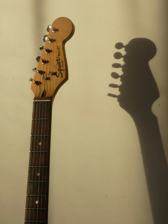 an electric guitar laying upright with its neck up