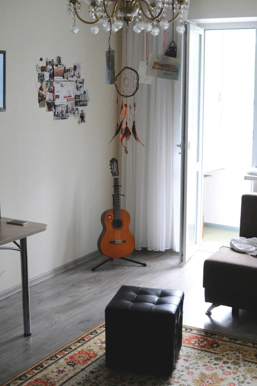 a living room with a guitar, couch and chandelier