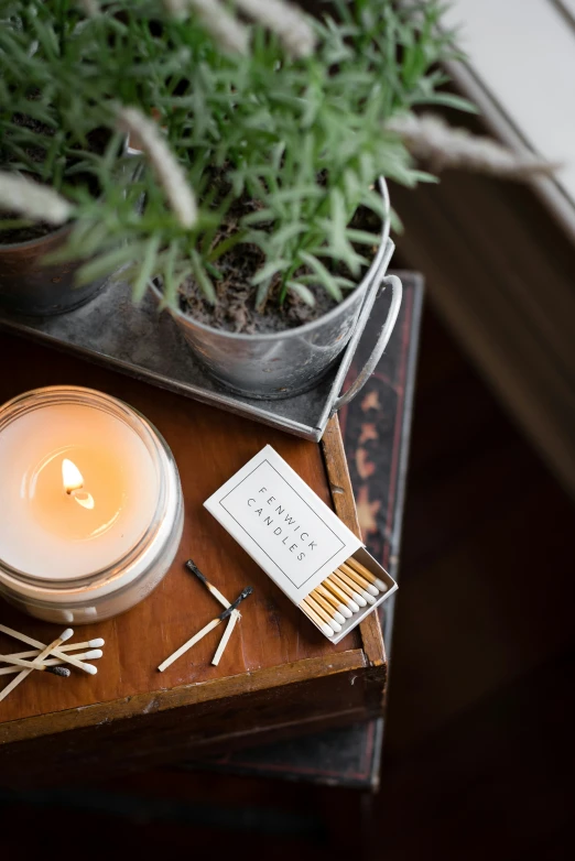 a lighted candle next to matches and a cigarette