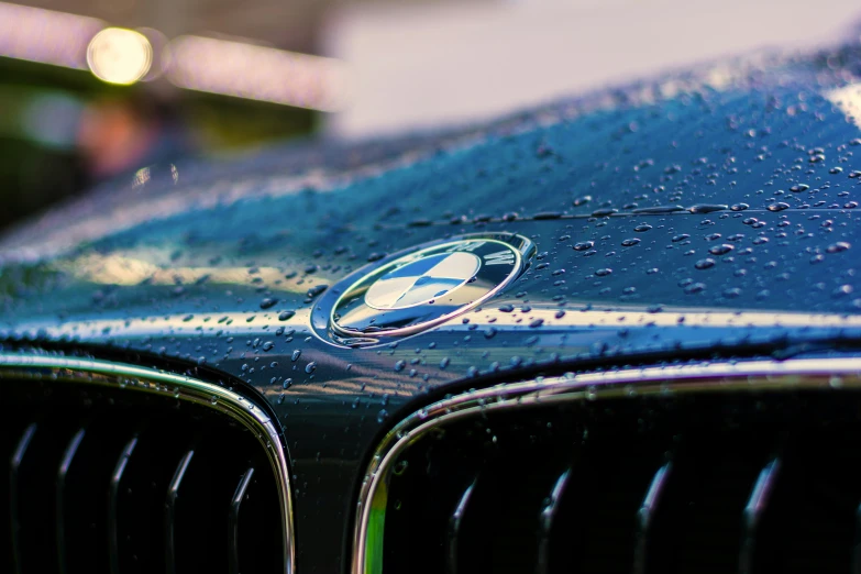 a blue car with a small logo on the hood