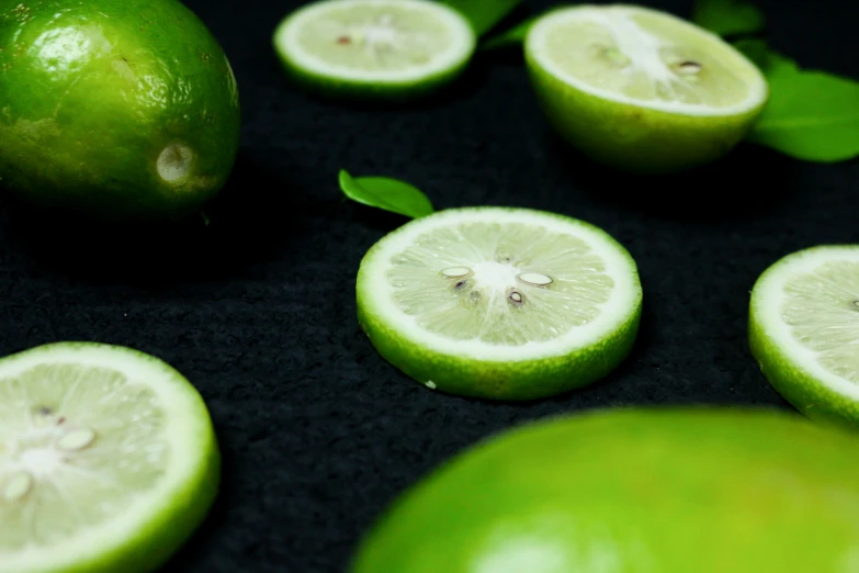 a group of limes with leaves and one cut in half