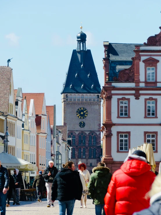 people walking in a street near old buildings